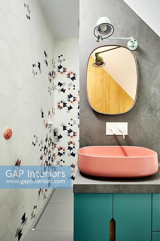 Blaugrünes und rosa Waschbecken gegen Betonwand im modernen Badezimmer