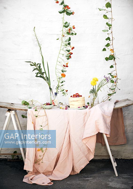 Gartentisch gefüllt mit Blumen und Picknickessen