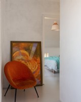 Orangefarbener Sessel, der auf dem Hintergrund des Gemäldes steht