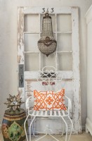 Ein ägyptischer Kristallkronleuchter vereint sich mit einer Vintage-Tür und einem Gartenstuhl.