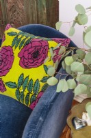 Ein Vintage-Kissen mit Rosenmuster von Marimenko bildet einen kräftigen Kontrast zum dunkelblauen Stuhl.