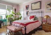 Eine Farbpalette aus Rosa, Türkis und Rot verleiht dem hellen und luftigen Schlafzimmer Romantik.