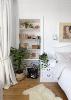Nischenregal im weißen Schlafzimmer mit Holzboden