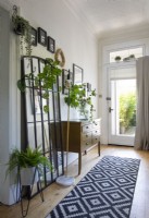 Zimmerpflanzen und schwarz-weiße Läufermatte im modernen Flur