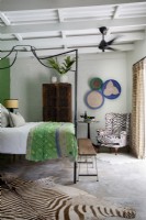 Schlafzimmer mit Himmelbett aus Metall und vielseitigem Dekor