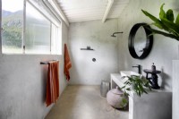 Minimalistisches Badezimmer mit Estrichwänden und -boden
