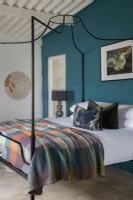 Schlafzimmer mit Himmelbett und blaugrüner Wand