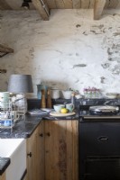 Küchenarbeitsplatte mit Aga-Herd und weiß getünchten Wänden