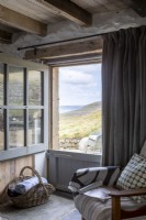 Bequemer Sitz neben dem großen Sichtfenster, dahinter die Küste Cornwalls