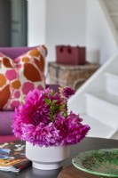 Leuchtend rosa und violette Blumen auf dem Couchtisch – Detail