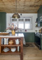 Pendelleuchte über einer Holzinsel in einer Landhausküche