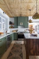Landhausküche mit grünen Schränken und Holzdecke