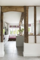 Blick durch freiliegende Holzbalken in die Landhausküche 