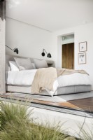 Schlafzimmer in neutralen Farbtönen mit Wandleuchten 