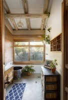 Badezimmer mit freiliegenden Holzbalken und großem Panoramafenster 