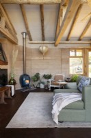 Wohnzimmer mit Stampflehmwänden und freiliegenden Holzbalken 